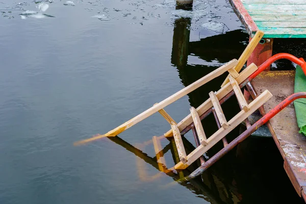 川や貯水池の銀行の桟橋で木製の階段 穴の中で泳ぐ伝統的な宗教的な休日の洗礼 テキストのコピースペースを持つ背景 — ストック写真