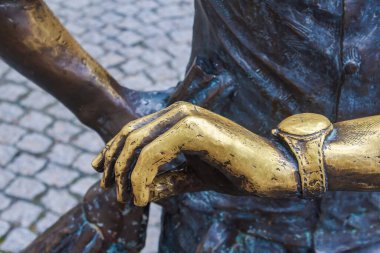 Elinde bronz heykel saati elementi var. Gecikme ve bekleme konsepti. Metin ve seçici odak için kopyalama alanı olan arkaplan