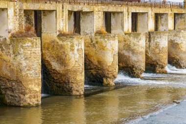 Küçük bir nehirde terk edilmiş eski bir hidroelektrik santrali. Metin için kopyalama alanı olan Apokaliptik arkaplan.