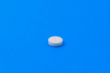 Klasik mavi arka planda puanı olan beyaz ilaç. Metin veya harf için kopyalama alanı olan seçici odak