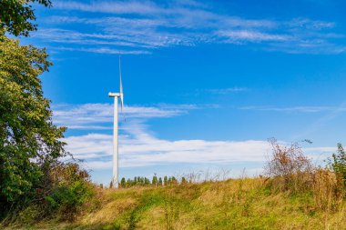 Elektrik üretimi için yel değirmenleri. Yeşil enerji konsepti. Metin için kopyalama alanı olan arkaplan. Şehrin dışındaki modern çiftlik..