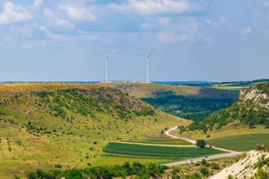 Elektrik üretimi için yel değirmenleri. Yeşil enerji konsepti. Metin için kopyalama alanı olan arkaplan. Şehrin dışındaki modern çiftlik..