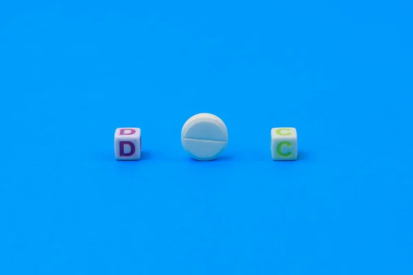 キューブで作られたDocテキスト 手紙Oの代わりにスコアを持つ白い医療用錠剤 古典的な青の背景 — ストック写真