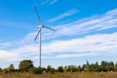 Elektrik üretimi için yel değirmenleri. Yeşil enerji konsepti. Metin için kopyalama alanı olan arkaplan. Şehrin dışındaki modern çiftlik..
