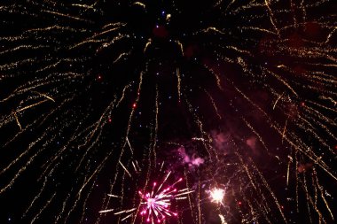 Havai fişekler, metin veya yazıtlar için kopyalama alanı olan karanlık bir gökyüzü zemininde kıvılcımlar saçar. Tasarım için grafik bir kaynak. Tasarımcı için boş. Altını çiz ya da altını.