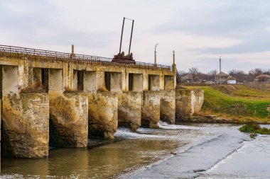 Küçük bir nehirde terk edilmiş eski bir hidroelektrik santrali. Metin için kopyalama alanı olan Apokaliptik arkaplan.
