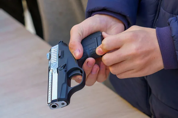 Ένα Όπλο Στα Χέρια Ενός Νεαρού Επιλεκτική Εστίαση Επαναφόρτωση Όπλων — Φωτογραφία Αρχείου