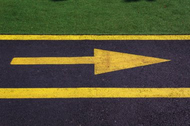 Sarı ok sağda, parktaki bisiklet yolunun siyah asfaltında. Metin için kopyalama alanı olan arkaplan