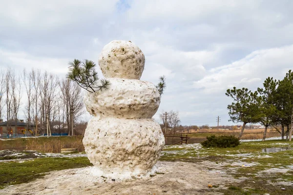 溶かした牧草地に巨大な春の雪だるま 文字やテキストのためのコピースペースを持つ背景 — ストック写真