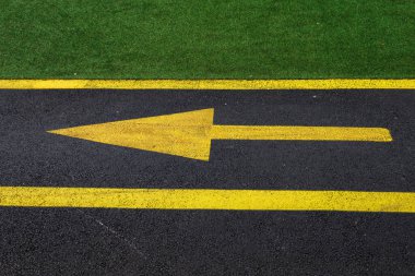 Sarı ok solda, parktaki bisiklet yolunun siyah asfaltında. Metin için kopyalama alanı olan arkaplan