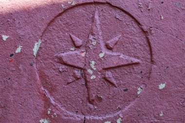 Taş grunge boyalı yüzeyde eski bir Windrose sembolü. Coğrafi azimlerin ve seyahatlerin haritalama sembolü.