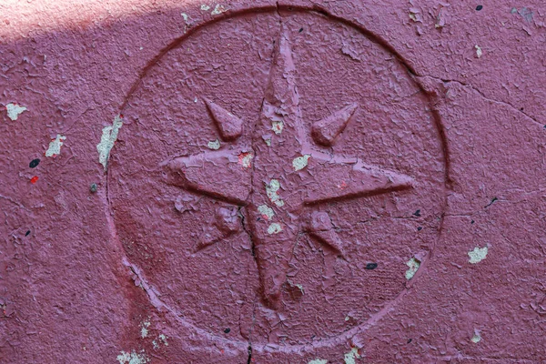 Taş grunge boyalı yüzeyde eski bir Windrose sembolü. Coğrafi azimlerin ve seyahatlerin haritalama sembolü.