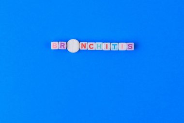 BRONCHITIS metni küpten yapılmış. O harfi yerine puanı olan beyaz bir ilaç. Klasik geleneksel mavi arkaplan.