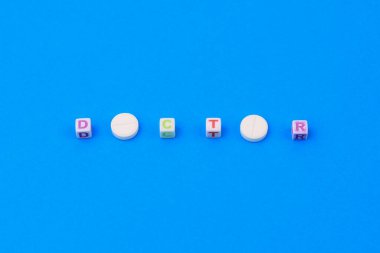 Doktor metni küpten yapılmış. O harfi yerine puanı olan beyaz bir ilaç. Klasik geleneksel mavi arkaplan.