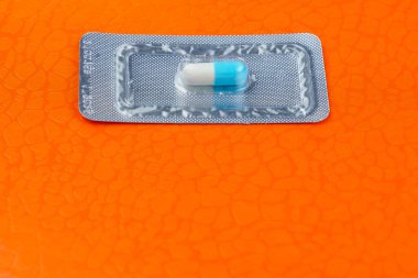 Çok önemli ve pahalı bir tablet ya da hap paketi. Turuncu arka plan. Seçici odak ve kopyalama alanı.