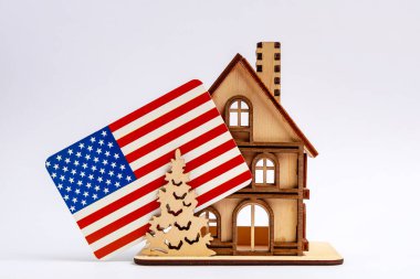 Baca ve arka planda Amerikan bayrağı olan tahta oyuncak sembolik bir ev..