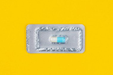 Çok önemli ve pahalı bir tablet ya da hap paketi. Sarı arka plan. Tıp ve farmakoloji.