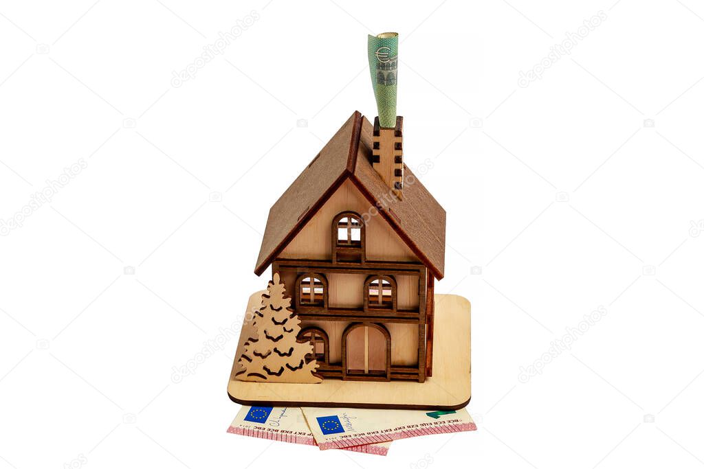 Euro bill in a chimney and a wooden toy symbolic house on a white isolated background. Heating concept