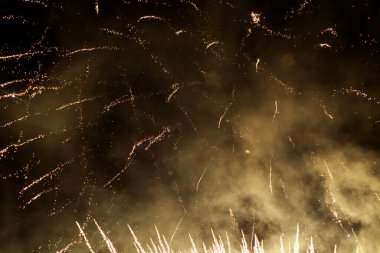 Havai fişekler, metin veya yazıtlar için kopyalama alanı olan karanlık bir gökyüzü zemininde kıvılcımlar saçar. Tasarım için grafik bir kaynak. Tasarımcı için boş. Altını çiz ya da altını.