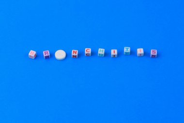 BRONCHITIS metni küpten yapılmış. O harfi yerine puanı olan beyaz bir ilaç. Klasik geleneksel mavi arkaplan.