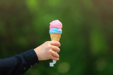 Bulanık yeşil park arka planında dondurmalı waffle külahı. Metin için seçici odak ve kopyalama alanı