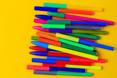 Karışık kepli çok renkli kalemler. Yaratıcı bir kavram. Seçici odaklı sarı arkaplan ve metin için alanı kopyala