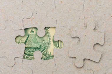 Kayıp yapboz parçası ve çerçevelenmiş Amerikan doları. Metin için kopyalama alanı olan arkaplan