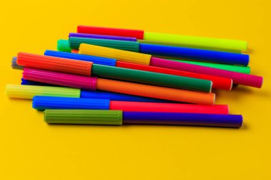 Karışık kepli çok renkli kalemler. Yaratıcı bir kavram. Seçici odaklı sarı arkaplan ve metin için alanı kopyala