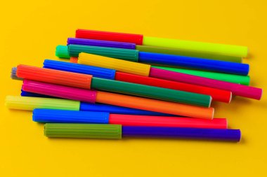 Karışık kepli çok renkli kalemler. Yaratıcı bir kavram. Seçici odaklı sarı arkaplan ve metin için alanı kopyala