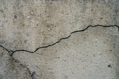 Çatlak beton levha. Çimentodan duvar ve çatlak. Ev temeli tamiri. Doku yüzeyi veya arkaplan
