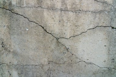 Çatlak beton levha. Çimentodan duvar ve çatlak. Ev temeli tamiri. Doku yüzeyi veya arkaplan