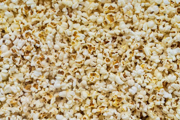 Close up of popcorn behind glass for sale at the international street food festival. Background texture. Traditional festive cuisine