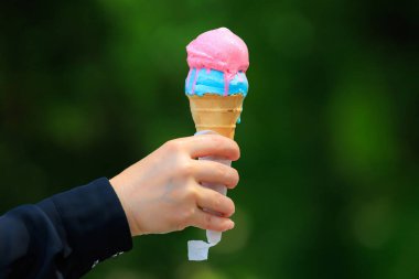 Bulanık yeşil park arka planında dondurmalı waffle külahı. Metin için seçici odak ve kopyalama alanı