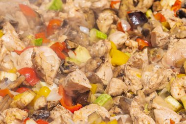 Uluslararası sokak yemekleri festivalinde et ve sebzeleri büyük bir kızartma tavasında satılığa çıkar. Özenle seçilmiş bir arka plan. Geleneksel festival mutfağı