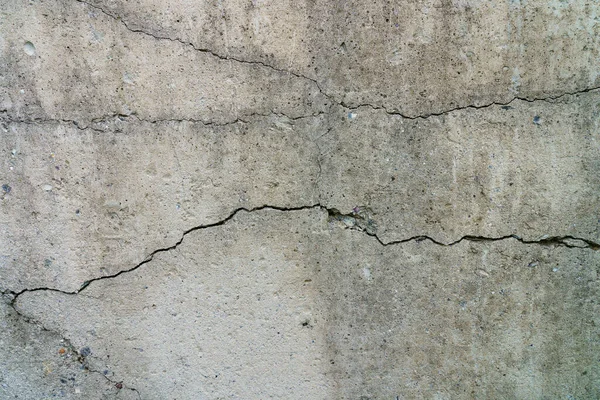 Çatlak beton levha. Çimentodan duvar ve çatlak. Ev temeli tamiri. Doku yüzeyi veya arkaplan