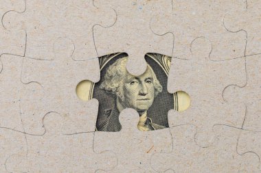 Kayıp yapboz parçası ve çerçevelenmiş Amerikan doları. Metin için kopyalama alanı olan arkaplan