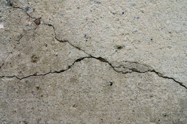 Çatlak beton levha. Çimentodan duvar ve çatlak. Ev temeli tamiri. Doku yüzeyi veya arkaplan