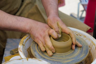 Potter çömlekçi çarkı üzerinde çalışıyor. Eller yakın çekim. Metin için kopyalama alanı olan arkaplan