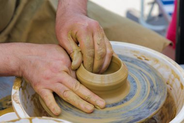 Potter çömlekçi çarkı üzerinde çalışıyor. Eller yakın çekim. Metin için kopyalama alanı olan arkaplan