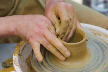 Potter çömlekçi çarkı üzerinde çalışıyor. Eller yakın çekim. Metin için kopyalama alanı olan arkaplan