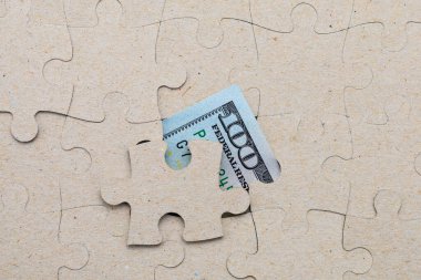 Kayıp yapboz parçası ve çerçevelenmiş Amerikan doları. Metin için kopyalama alanı olan arkaplan