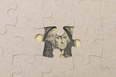 Kayıp yapboz parçası ve çerçevelenmiş Amerikan doları. Metin için kopyalama alanı olan arkaplan