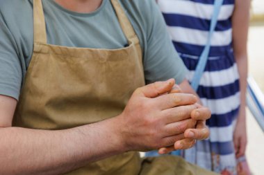 The potter kneads the clay. Close-up hands. Background with copy space for text