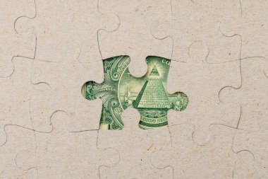 Kayıp yapboz parçası ve çerçevelenmiş Amerikan doları. Metin için kopyalama alanı olan arkaplan