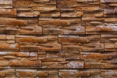 Textured rough surface of decorative natural stone wall. Background or backdrop. A blank for design or a graphic resource for a designer. Exterior decoration of buildings