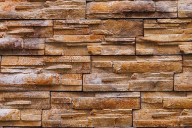 Dekoratif doğal taş duvarın pürüzlü yüzeyi. Arkaplan ya da fon. Tasarım için boşluk ya da bir tasarımcı için grafik kaynak. Binaların dış dekorasyonu