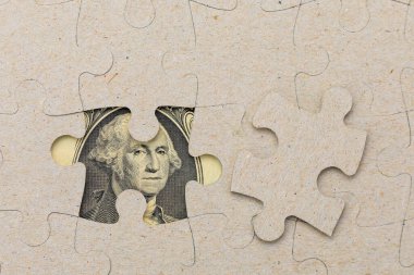 Kayıp yapboz parçası ve çerçevelenmiş Amerikan doları. Metin için kopyalama alanı olan arkaplan