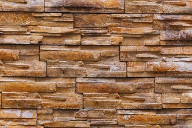 Dekoratif doğal taş duvarın pürüzlü yüzeyi. Arkaplan ya da fon. Tasarım için boşluk ya da bir tasarımcı için grafik kaynak. Binaların dış dekorasyonu