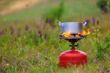 Pot on a gas burner in field conditions. Background with copy space for text
