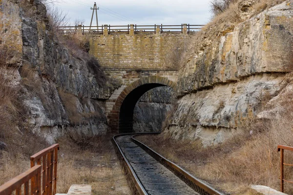 渓谷の鉄道トンネルと道路橋 ロシア語で1893年に書かれた テキストのコピースペースを持つ背景 — ストック写真